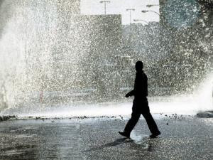 A man walks past a burst water pipe on the corner of West and Market streets in Joburg. Picture: Mujahid Safodien