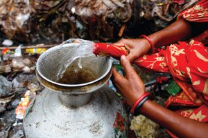 Woman in Dhaka, Bangladesh, filling water vessel.